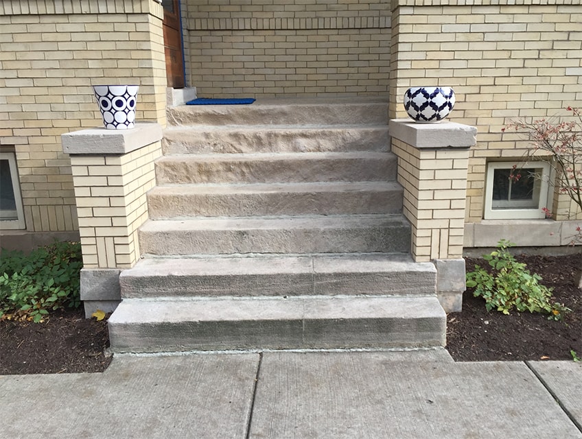 Limestone entryway steps with stoop walls rebuilt using original 95-year-old capstones and footers