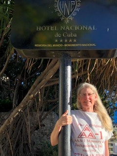 AAA-1 client Ann Halverson wearing her AAA-1 Masonry t-shirt while standing next to the Hotel Nacional de Cuba sign in Havana.