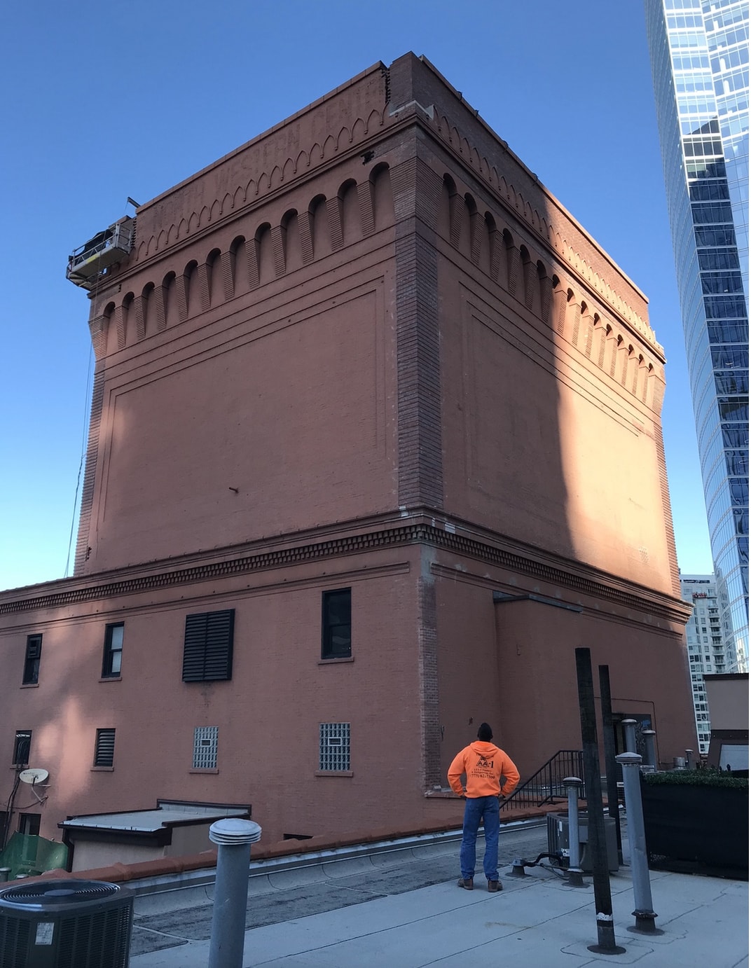 Foreman Mirek looks up at a brick elevator penthouse